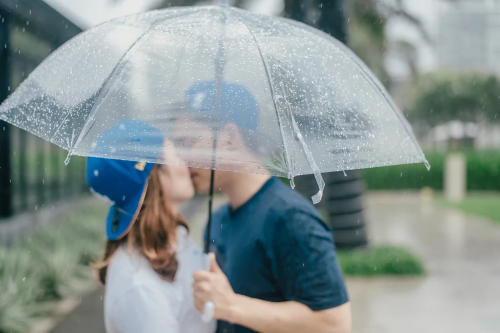 Man and woman kissing under an umbrella